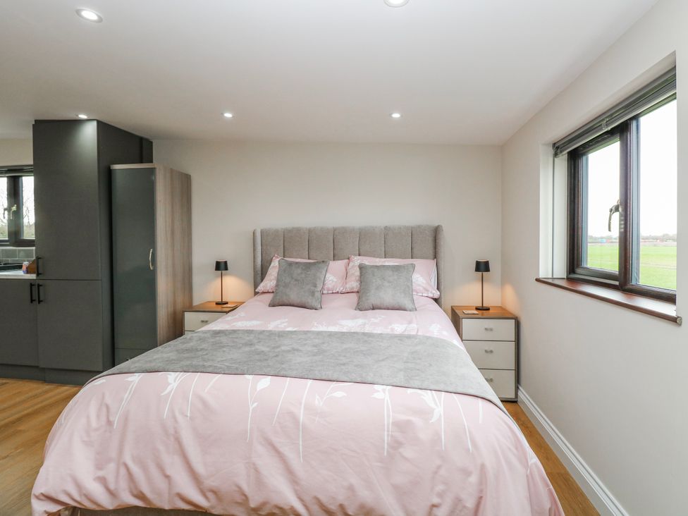 A bedroom with a bed and bedside tables at Aloe Lodge in Banham