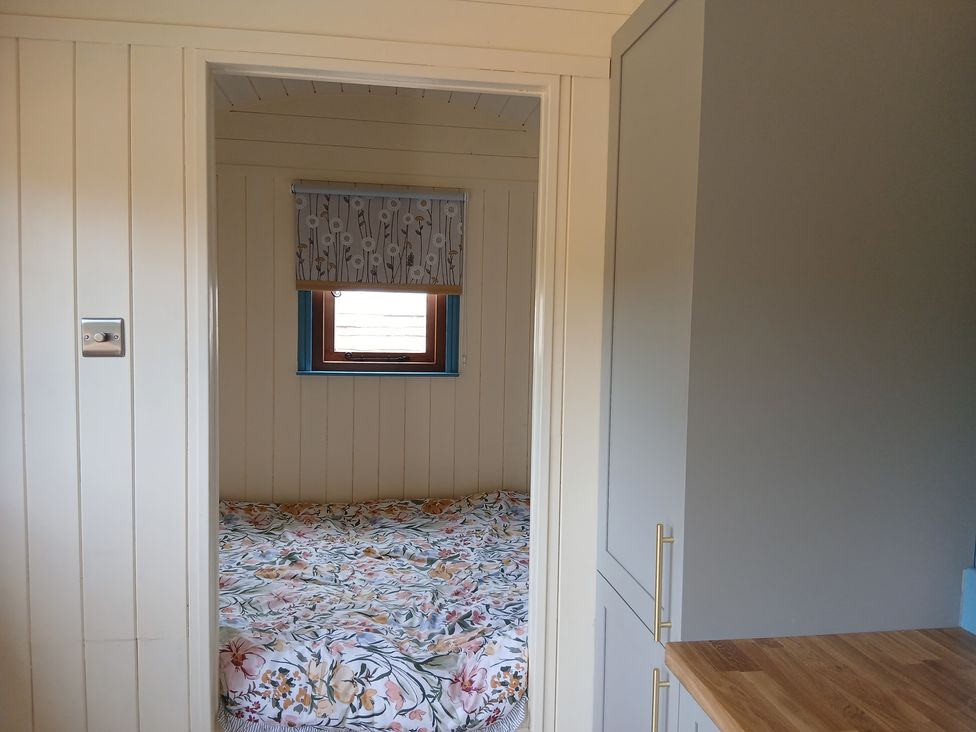 A bedroom with a bed and window at Woodie in Clee Hill