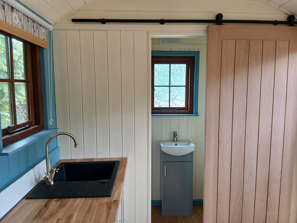 A kitchen with a sink and a door at Woodie in Clee Hill