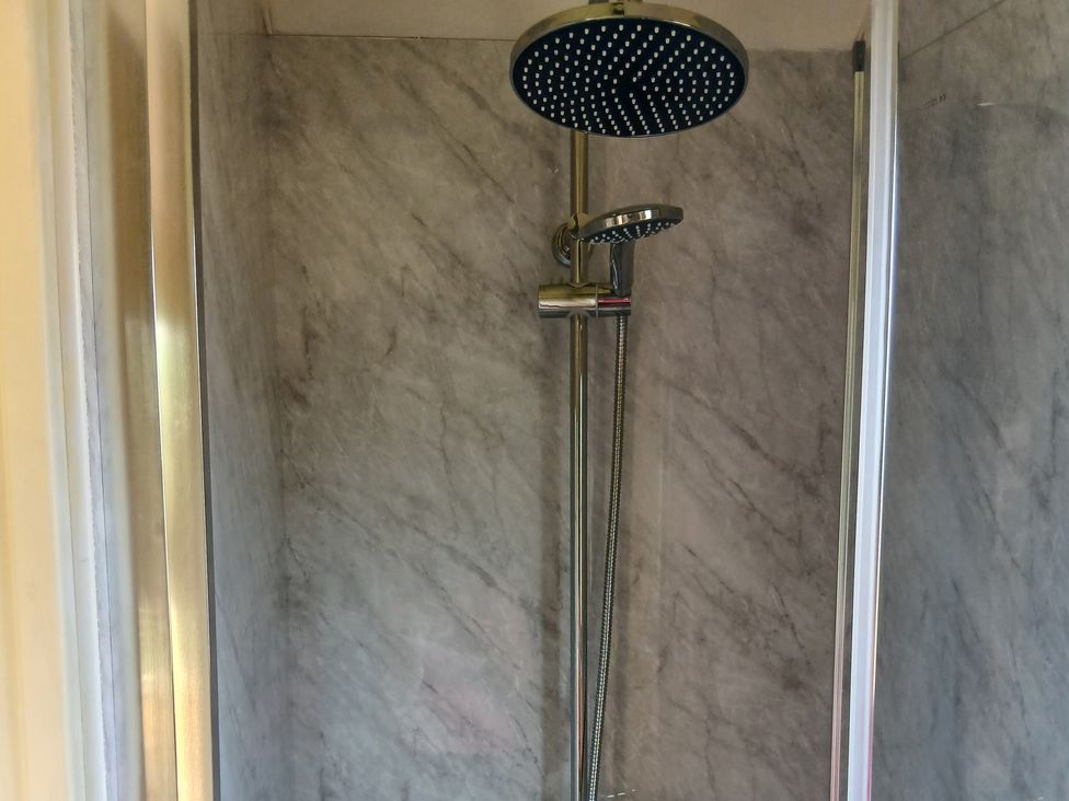 A shower with marble walls and fixtures at Woodie in Clee Hill