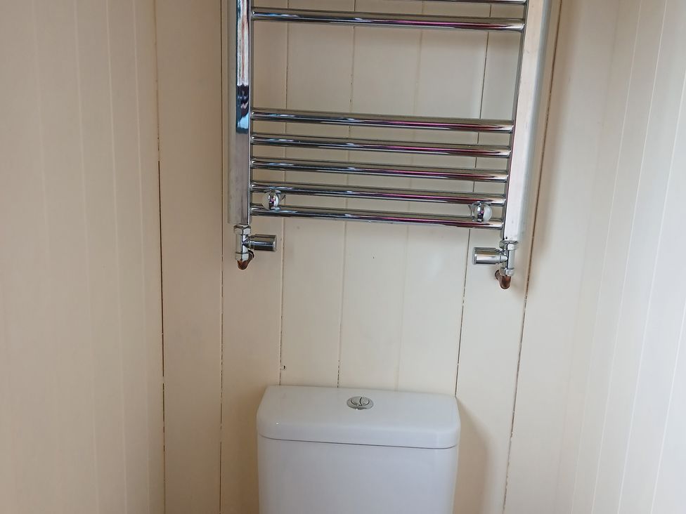 A bathroom with a toilet and towel rail at Woodie in Clee Hill