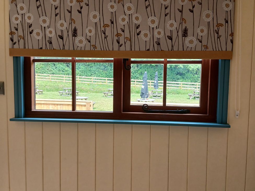 A window with a view of an outdoor seating area at Woodie in Clee Hill
