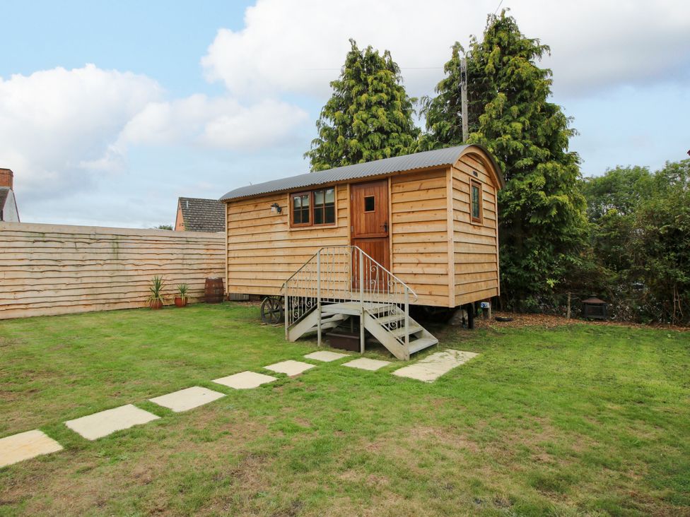 A shepherd's hut in a grassy area at Woodie in Clee Hill
