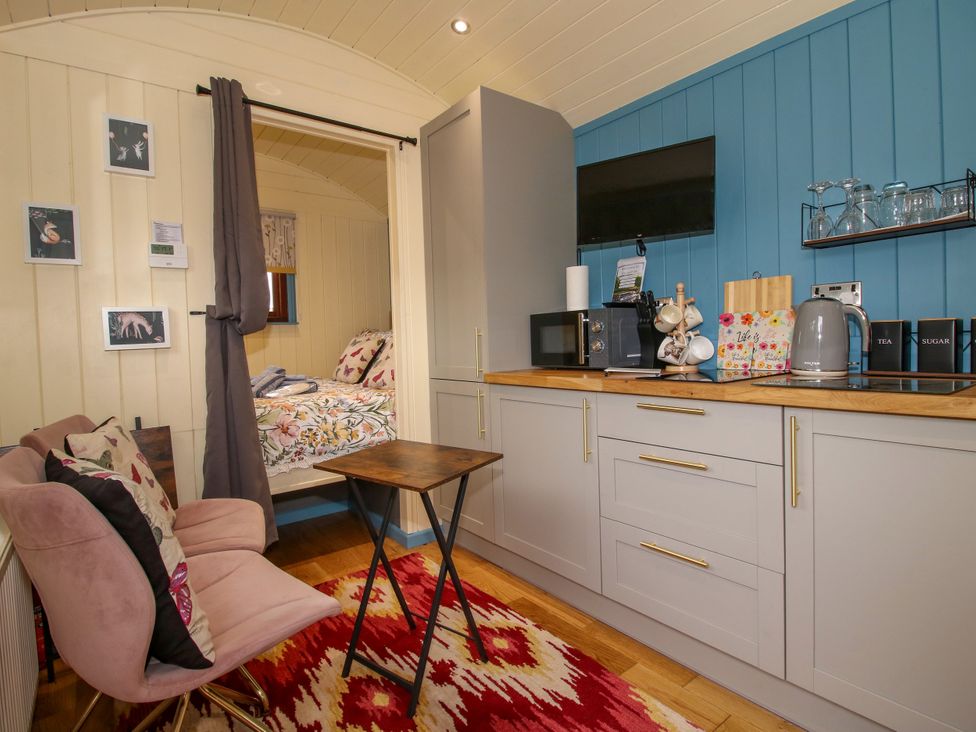A living room with kitchen cabinet and sofa at Woodie in Clee Hill