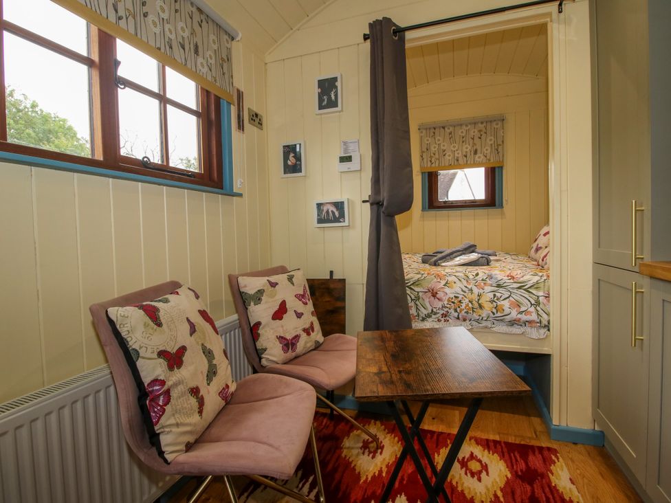 A bedroom with a bed and seating area at Woodie in Clee Hill