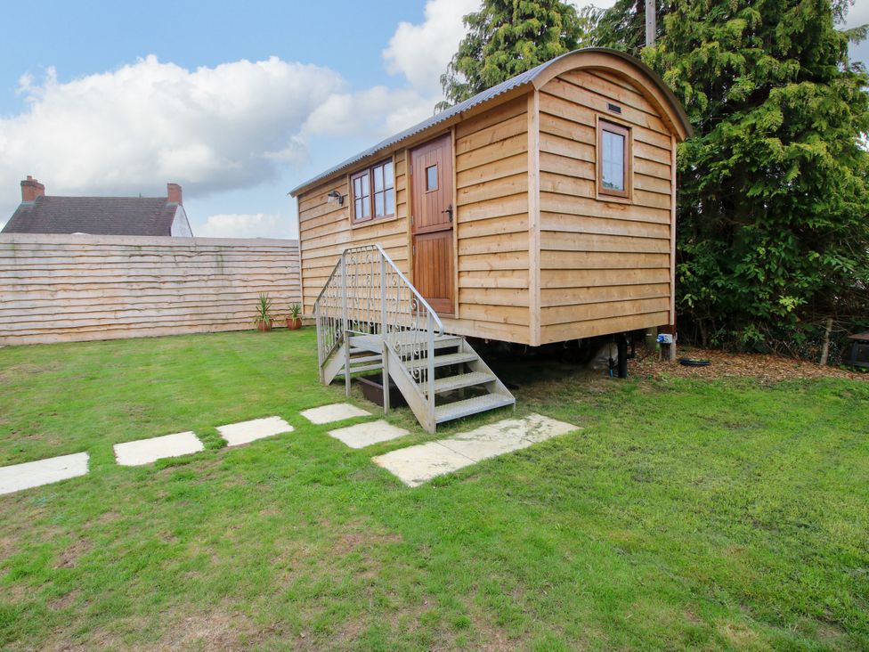 A wooden hut with stairs and pathway in an outdoor area at Woodie in Clee Hill
