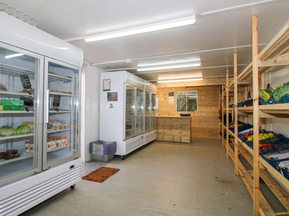 A grocery store with refrigerators and shelves at Woodie in Clee Hill