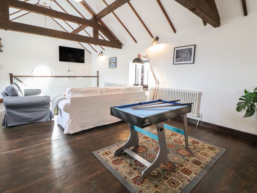 A living room with a pool table and sofa at Quarry Barn in Wrexham