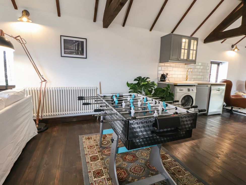 A recreation room with a foosball table and kitchen appliances at Quarry Barn in Wrexham