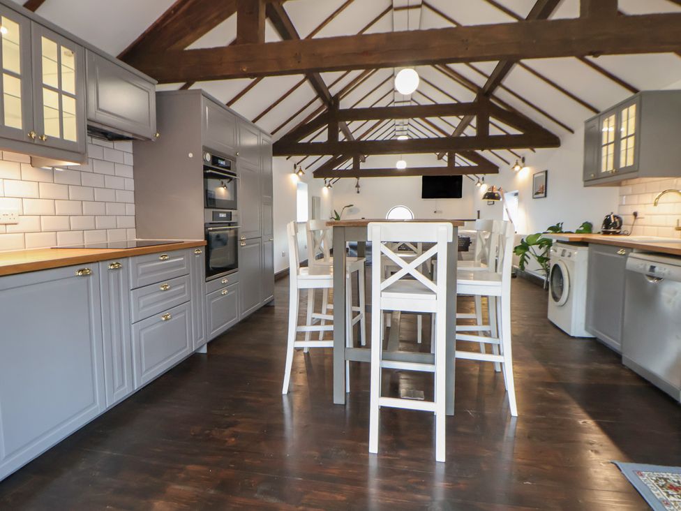 A kitchen with appliances and seating at Quarry Barn Wrexham