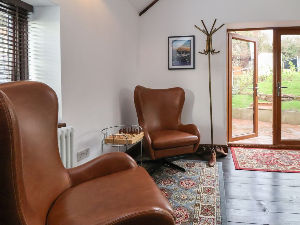 A snug area with two armchairs and a chess set at Quarry Barn in Wrexham