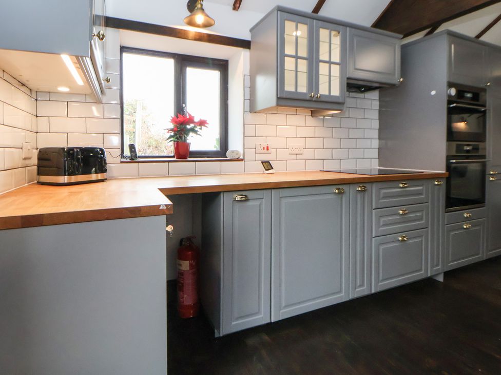 A kitchen with cabinets and a toaster at Quarry Barn in Wrexham