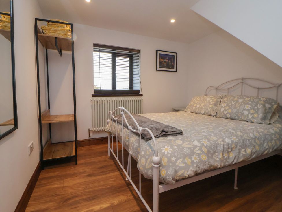 A bedroom with a bed and shelf at Quarry Barn in Wrexham