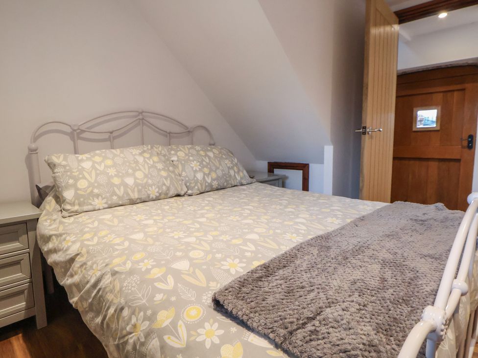 A bedroom with a bed and a bedside table at Quarry Barn in Wrexham