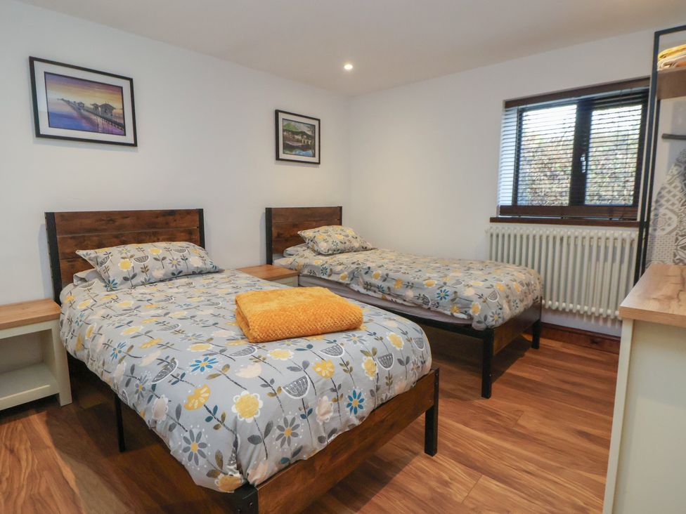 A bedroom with two beds and a window at Quarry Barn in Wrexham