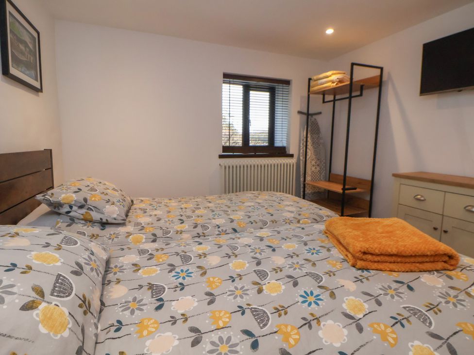 A bedroom with a bed and wardrobe at Quarry Barn in Wrexham