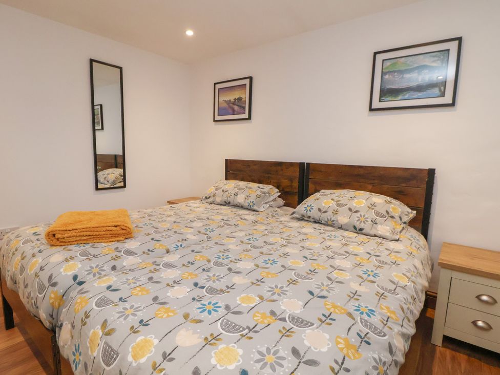 A bedroom with a bed and mirrors at Quarry Barn in Wrexham