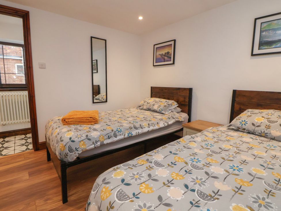 A bedroom with twin beds and a bedside table at Quarry Barn Wrexham