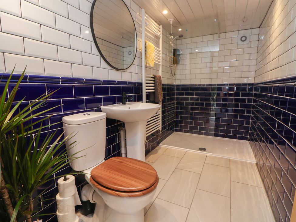 A bathroom featuring a toilet, sink, and shower at Quarry Barn in Wrexham