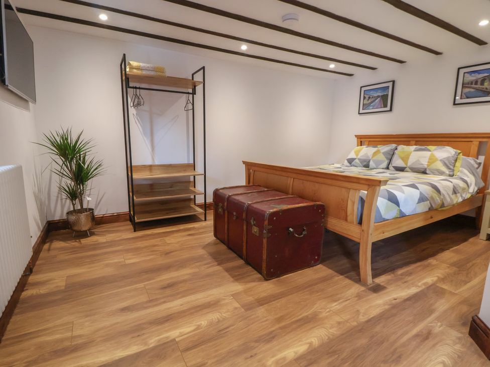 A bedroom with a bed and shelving unit at Quarry Barn in Wrexham