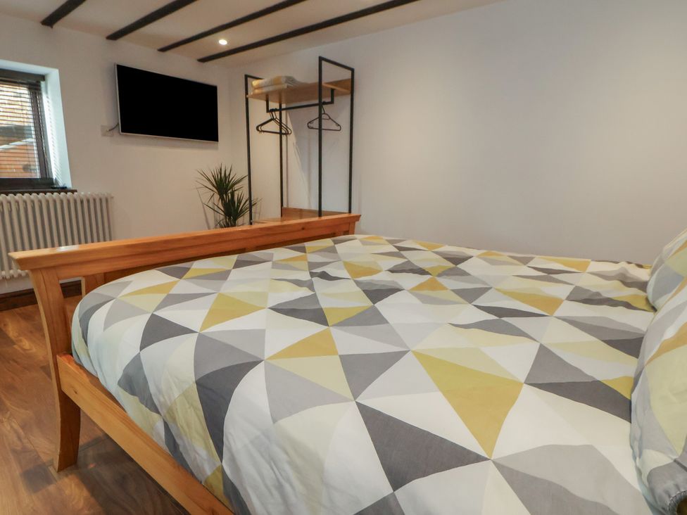 A bedroom with a bed and television at Quarry Barn in Wrexham