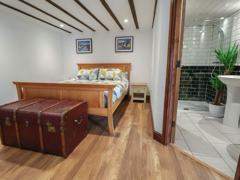 A bedroom with a bed and trunk at Quarry Barn in Wrexham