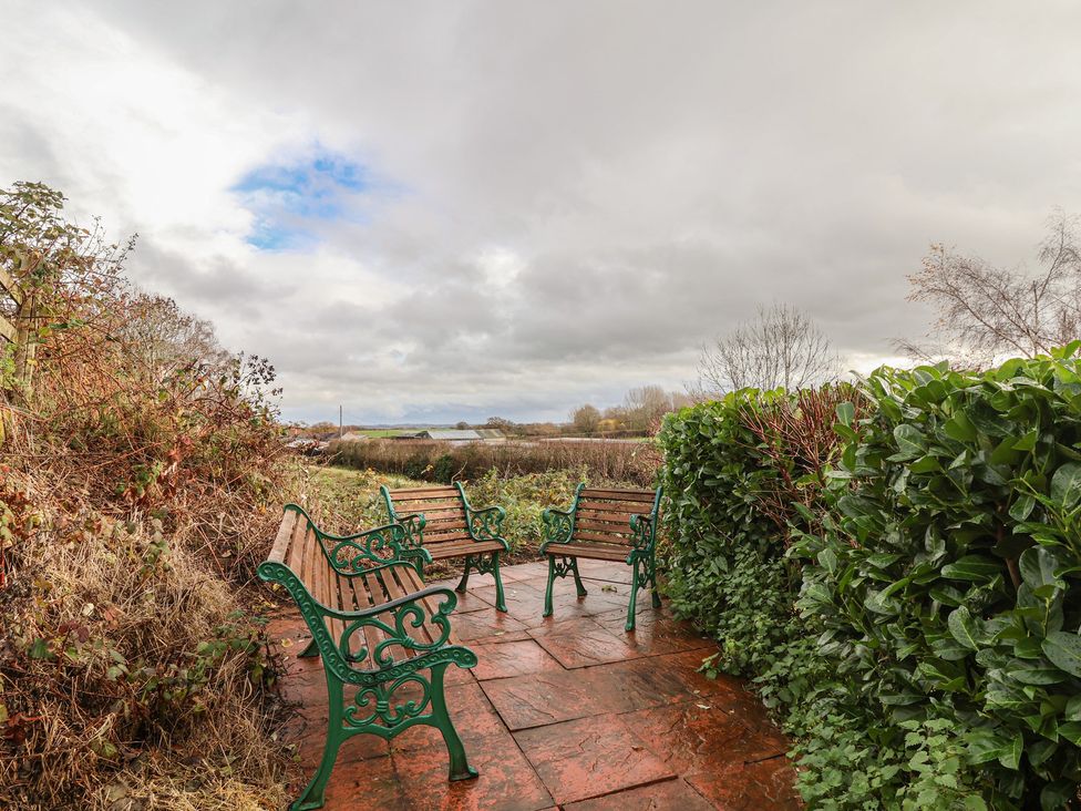 A garden with benches and greenery at Quarry Barn in Wrexham