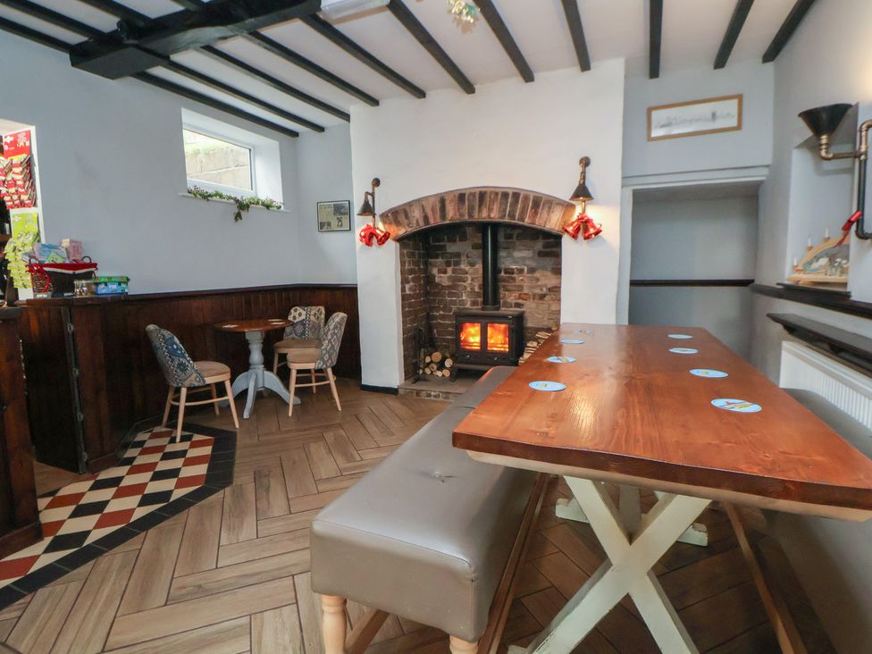A snug with a fireplace and seating area at Quarry Barn in Wrexham