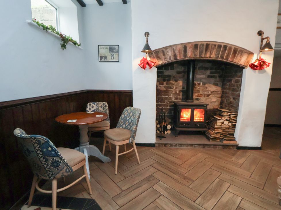 A snug with a fireplace and seating area at Quarry Barn in Wrexham
