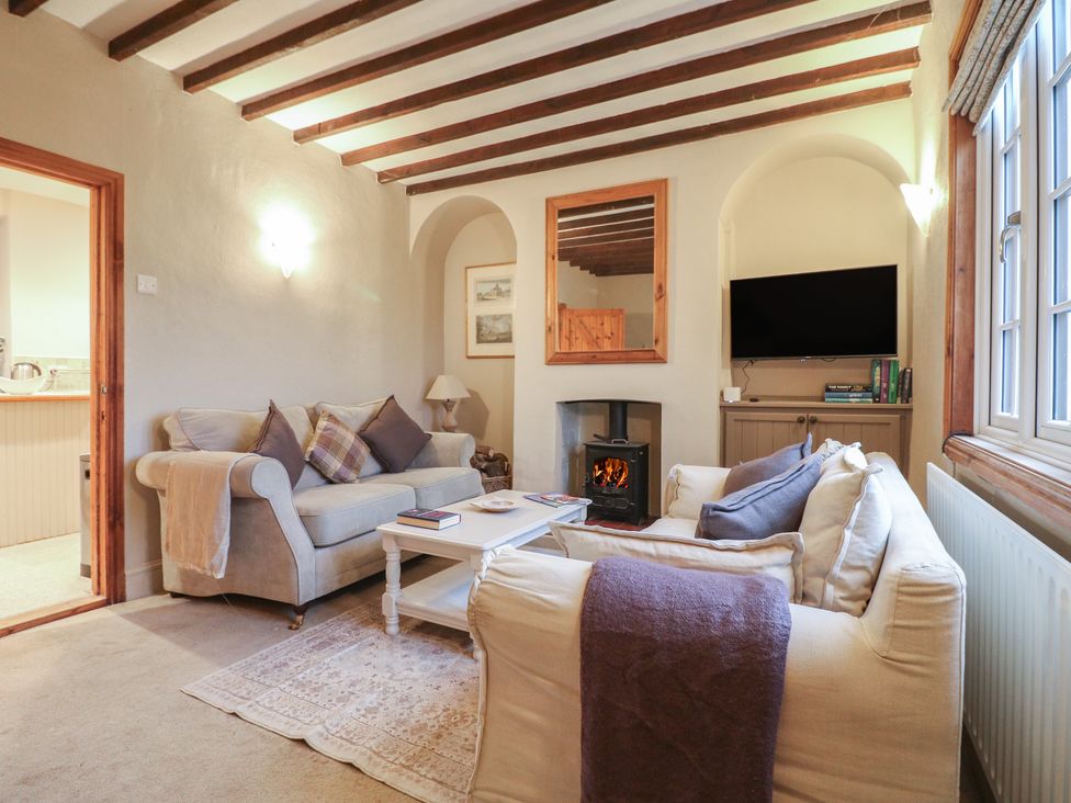 A living room with a fireplace and television at Little Launde Cottage in Launde near Braunston-In-Rutland