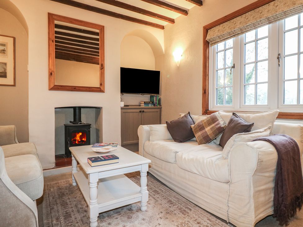 A living room with a sofa and fireplace at Little Launde Cottage in Launde near Braunston-In-Rutland