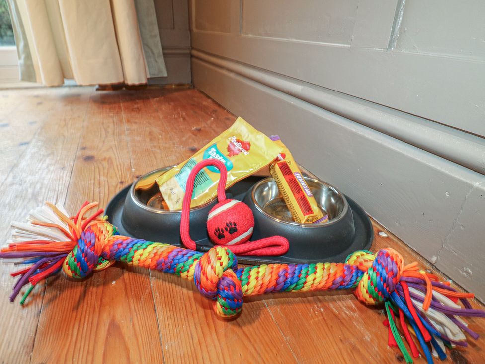 A dog food bowl with treats and toys at Little Launde Cottage in Launde near Braunston-In-Rutland