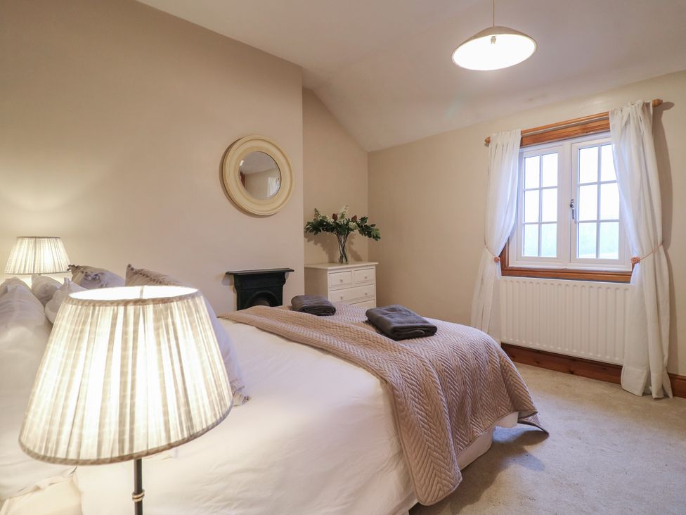 A bedroom with a bed and lamp at Little Launde Cottage Launde near Braunston-In-Rutland