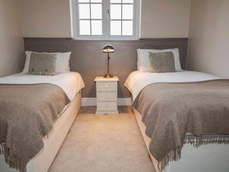 A bedroom with two beds and a lamp at Little Launde Cottage in Launde near Braunston-In-Rutland