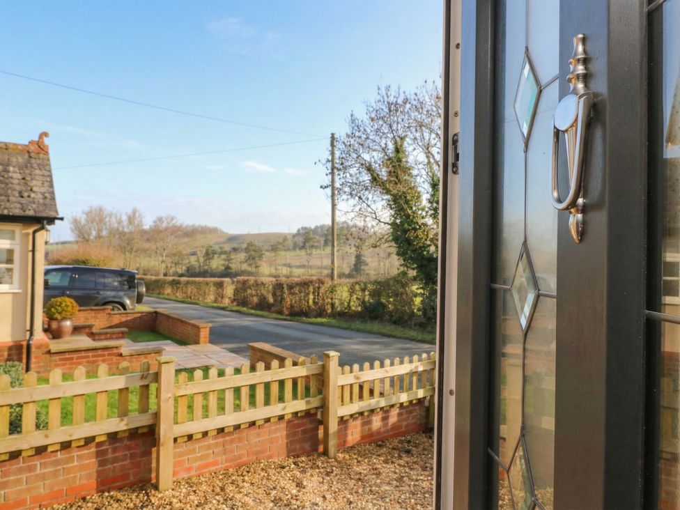 A view from a door towards a fence and road at Little Launde Cottage Launde near Braunston-In-Rutland