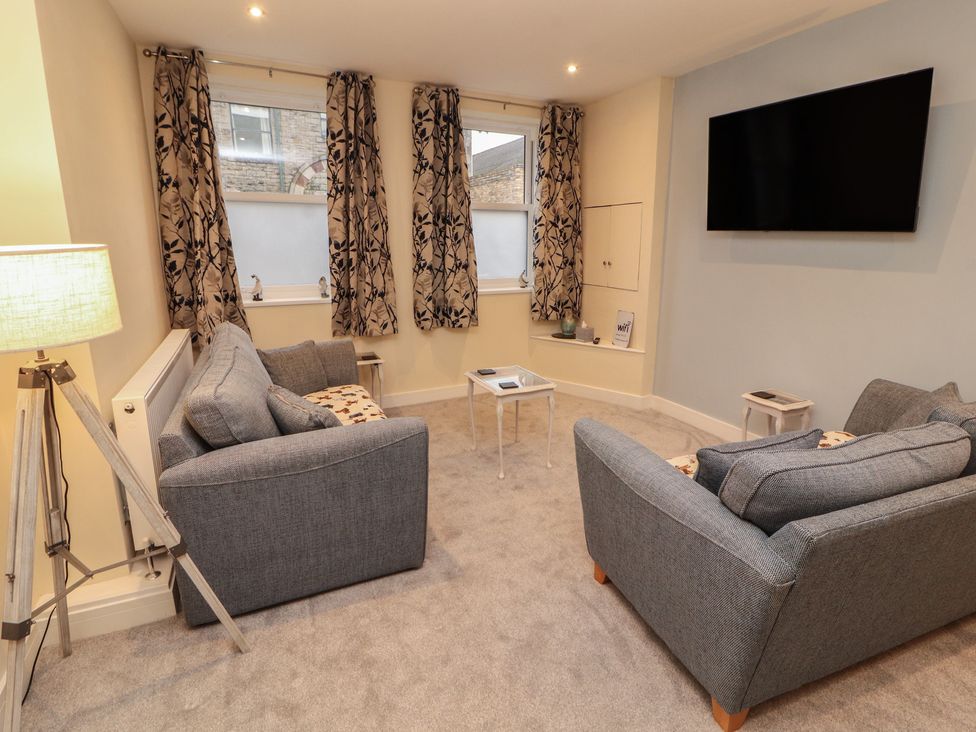 A living room with a TV and sofas at 20 Lorton Street in Cockermouth