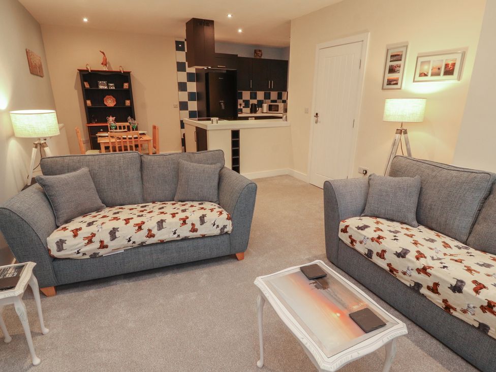 A living room with sofas and a dining area at 20 Lorton Street in Cockermouth