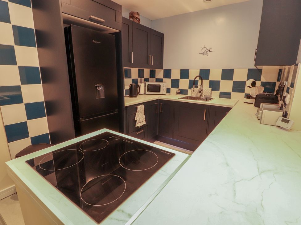 A kitchen with appliances and a cooking hob at 20 Lorton Street Cockermouth