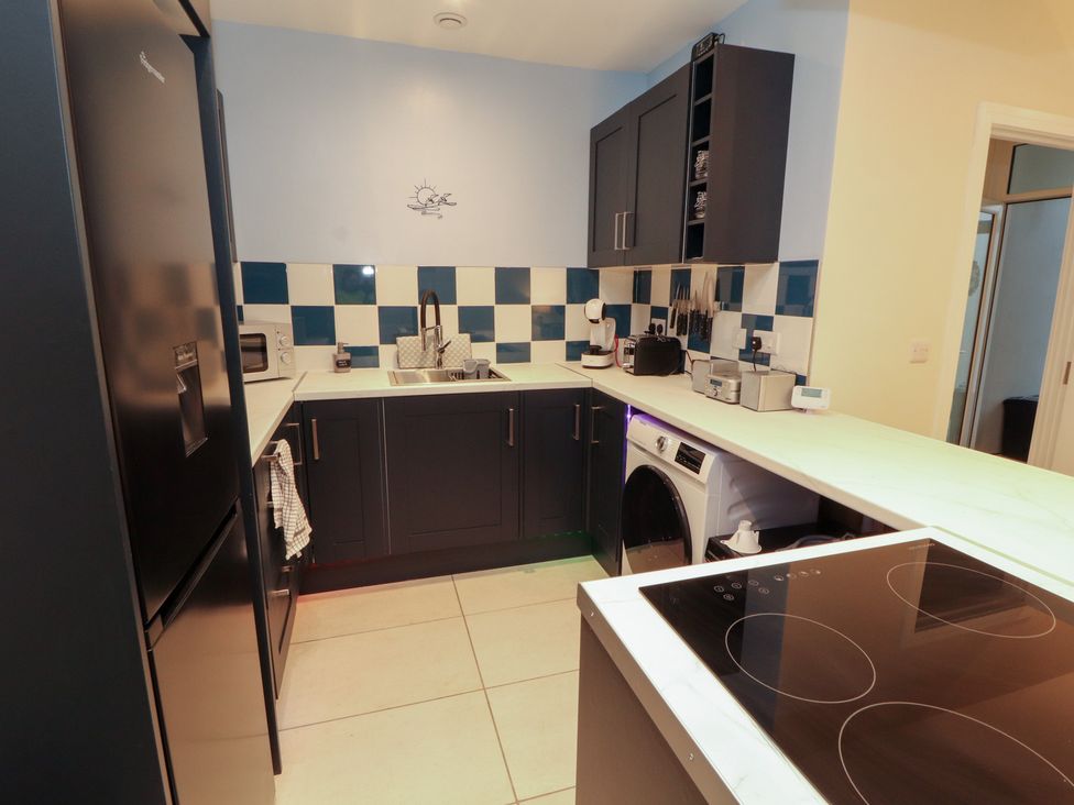 A kitchen with fridge, sink, oven and washing machine at 20 Lorton Street Cockermouth