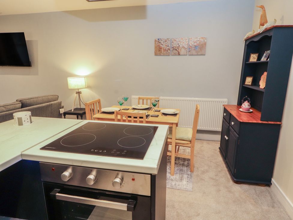 A dining area with a table and chairs next to a kitchen at 20 Lorton Street Cockermouth