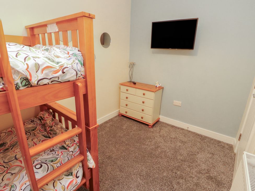 A bedroom with a bunk bed and television at 20 Lorton Street Cockermouth