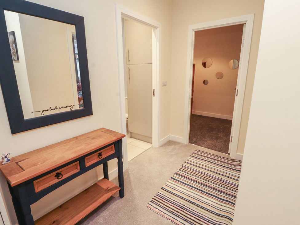 A hallway with a console table and a mirror at 20 Lorton Street in Cockermouth