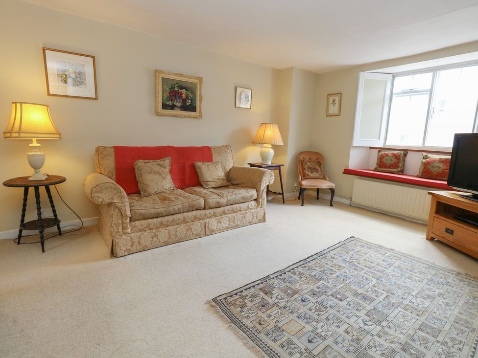 A living room with a sofa and lamp at Crantock