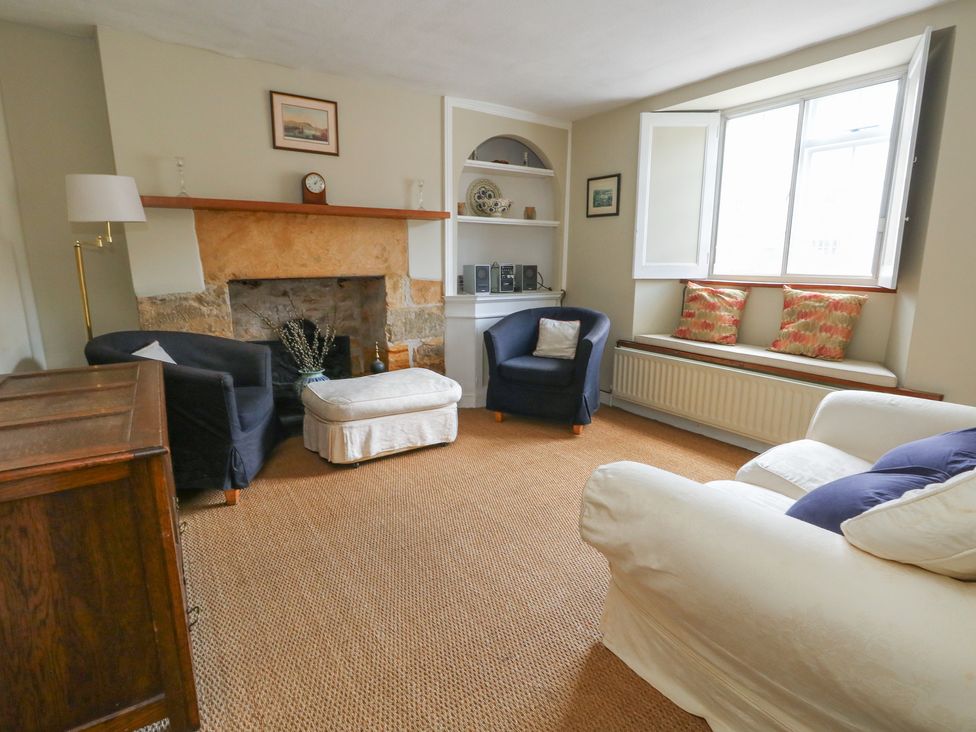 A living room with a fireplace and seating at Crantock