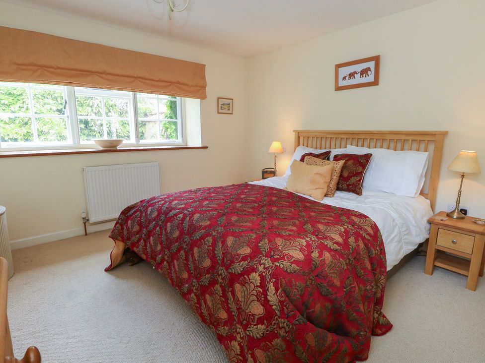A bedroom with a bed and nightstand at Crantock