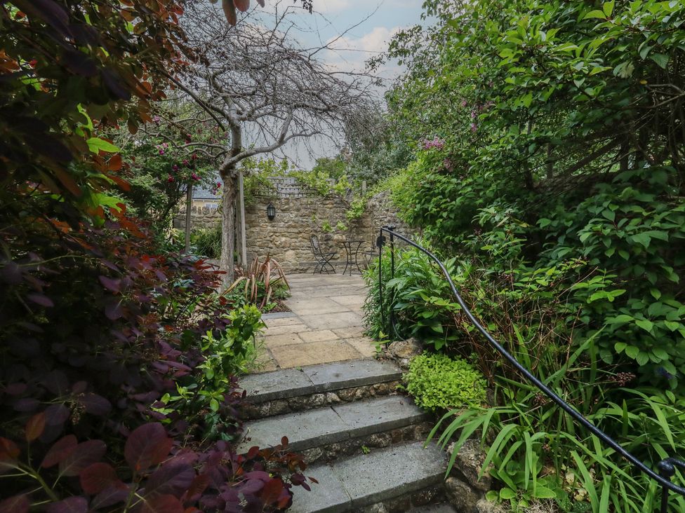 A garden with a pathway leading to a table and chairs at Crantock