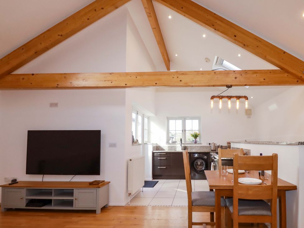 A kitchen and dining area with a table and chairs at The Maisonette in Hayle