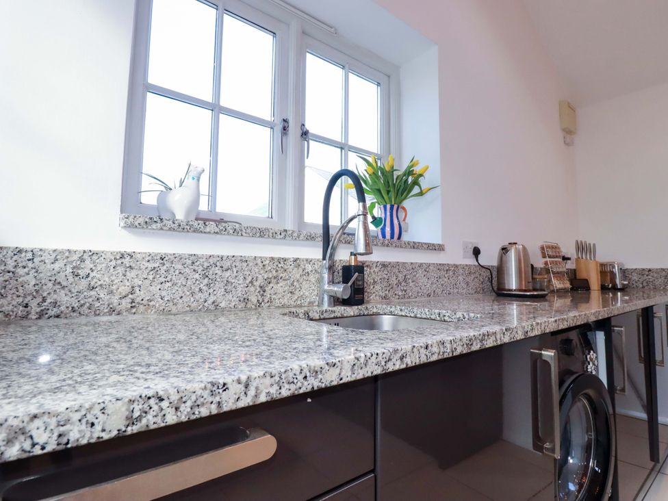 A kitchen with a sink and granite countertop at The Maisonette in Hayle