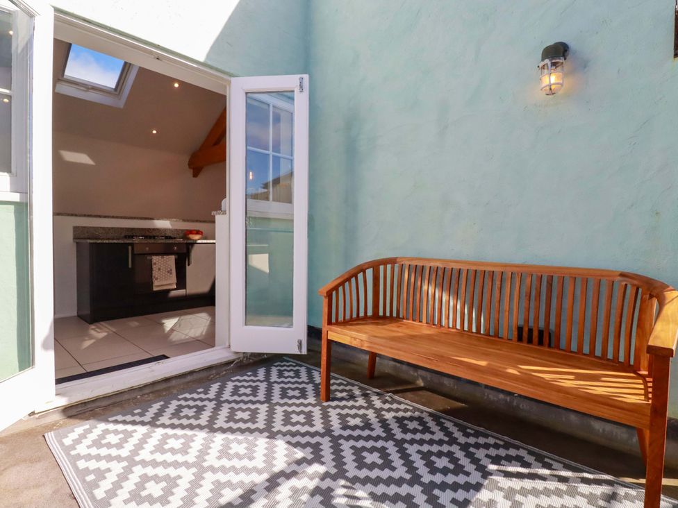 An outdoor space featuring a bench and a kitchen area at The Maisonette in Hayle