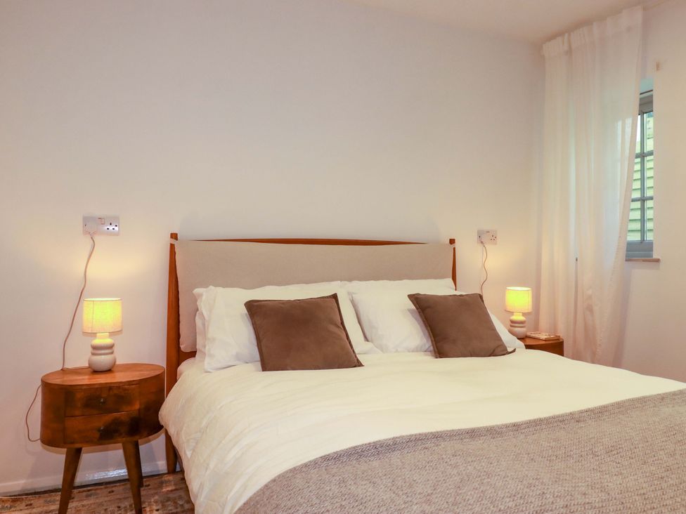 A bedroom with a bed and bedside tables at The Maisonette in Hayle